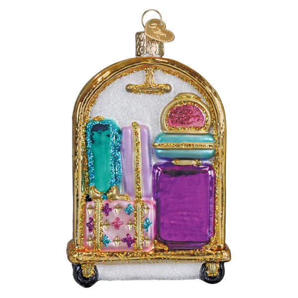 Ornament shaped as a luggage cart with pastel suitcases stacked on golden wheels.