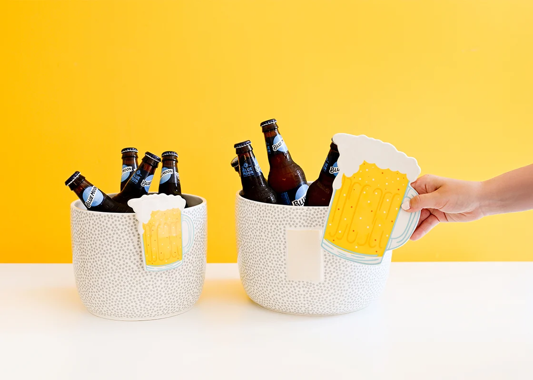 A hand placing a Beer Mug Big Attachment onto a white and grey dotted ceramic ice bucket.