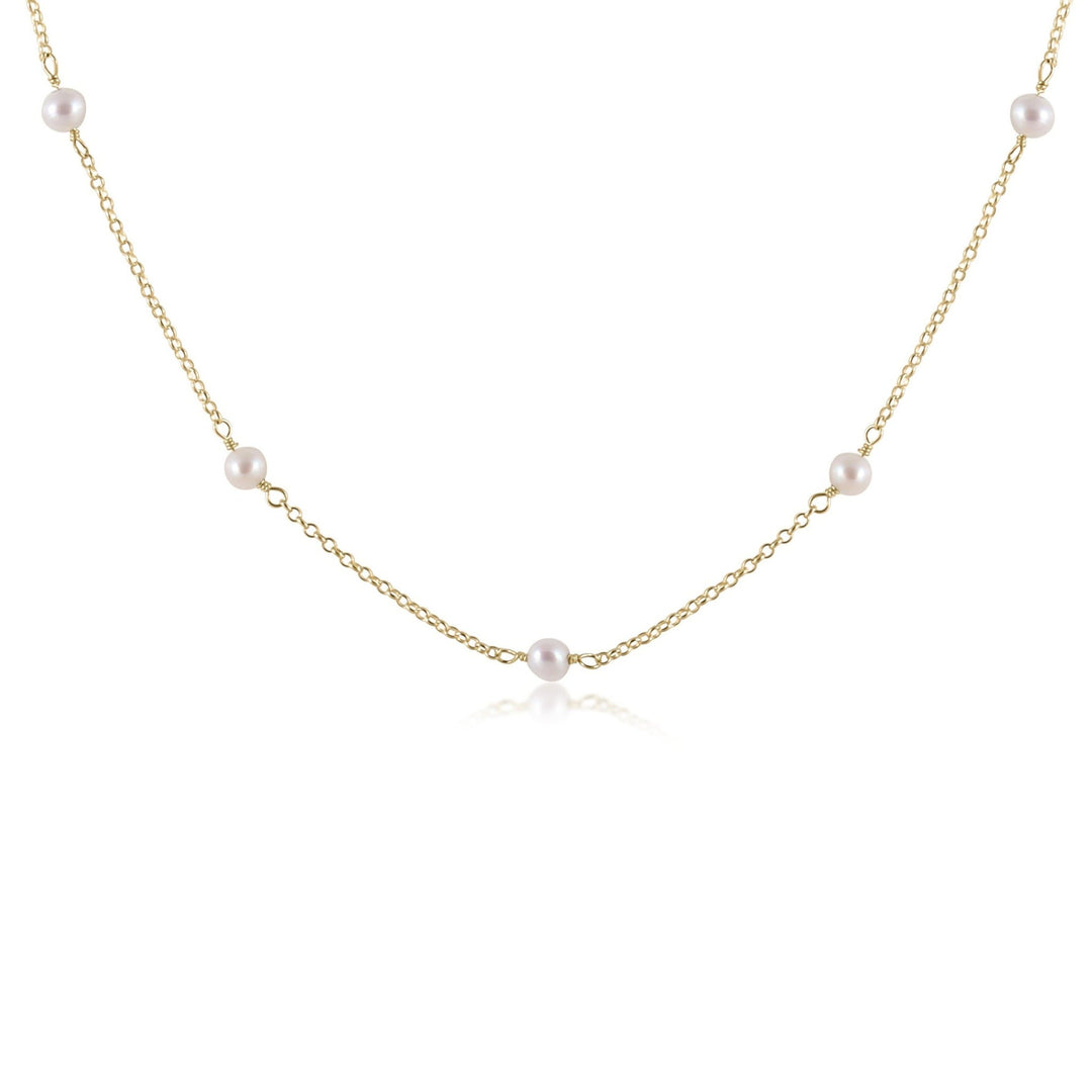 Gold choker necklace with a single 6mm pearl pendant.