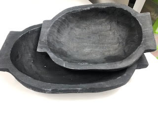 Two black oval dough bowls made of paulownia wood, one small and one large, nested together.