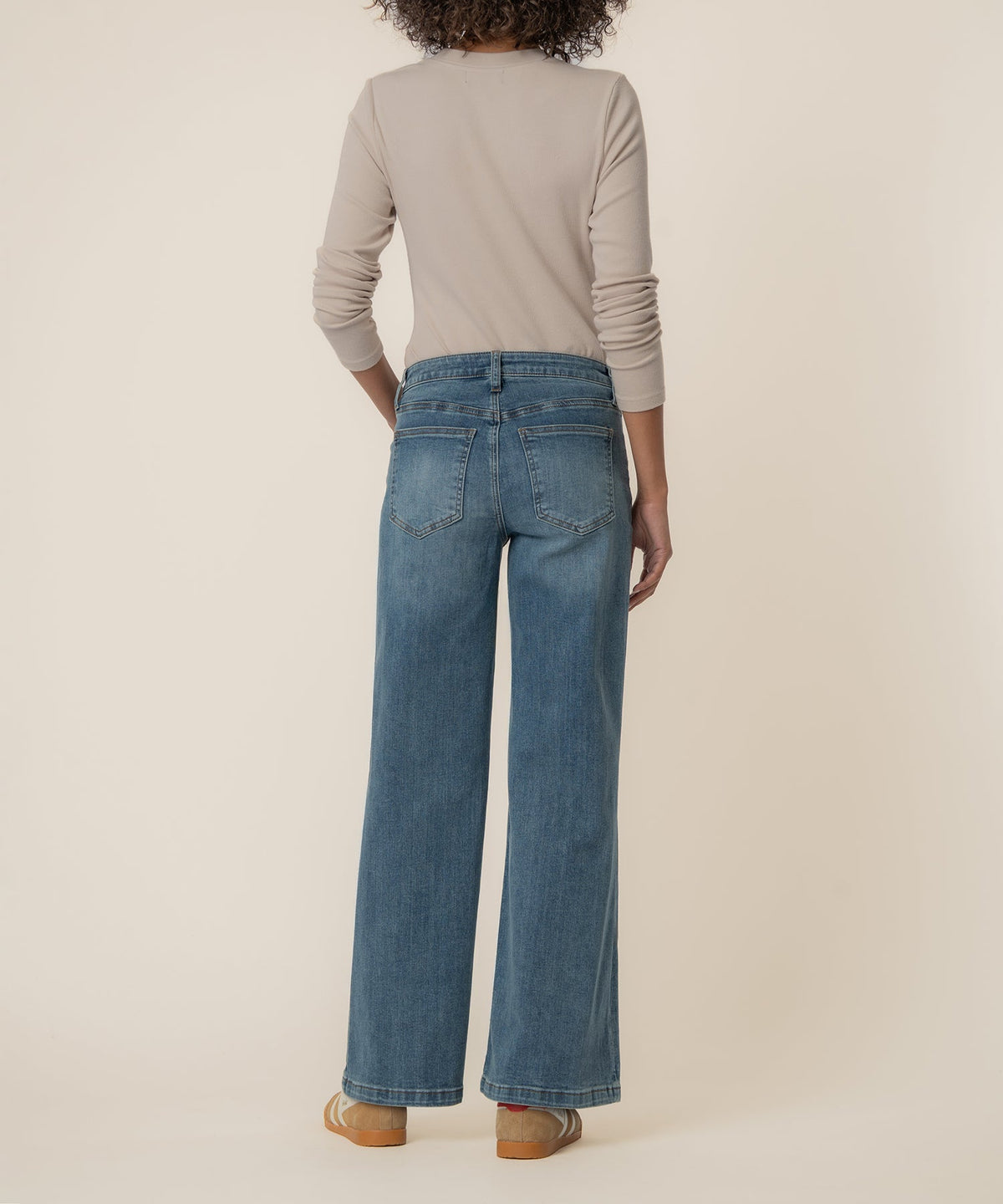 Back view of a person wearing Maya high-rise wide-leg blue jeans with a light beige long-sleeve top.