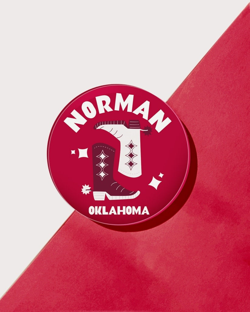 Four-inch round clear acrylic drink coaster with a collegiate theme.