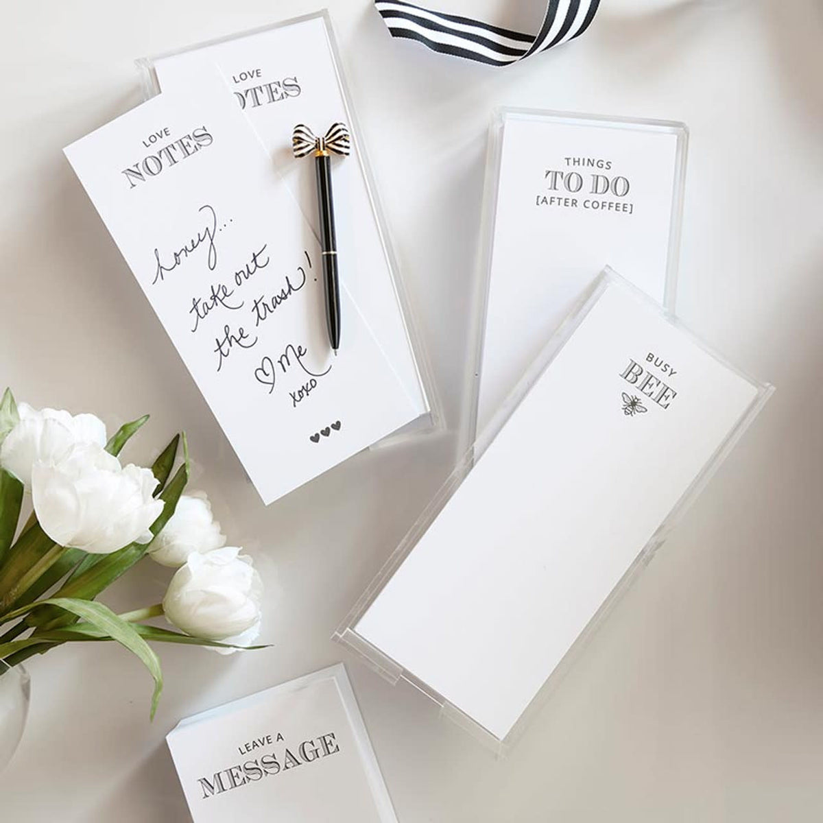 Clear acrylic notepaper tray holding loose leaf paper inserts with simple messages.
