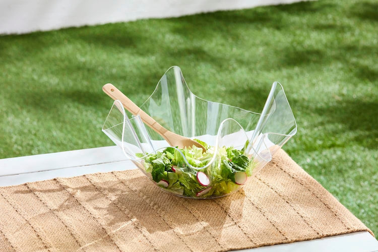 Two-piece acrylic ruffle bowl set in clear with wooden spoon included.