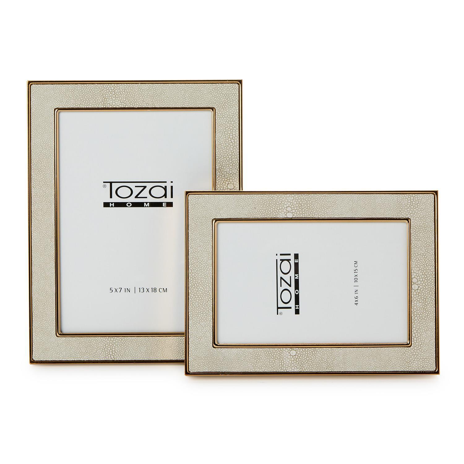 Two cream faux shagreen photo frames with gold steel trim in 5x7 and 4x6 sizes.