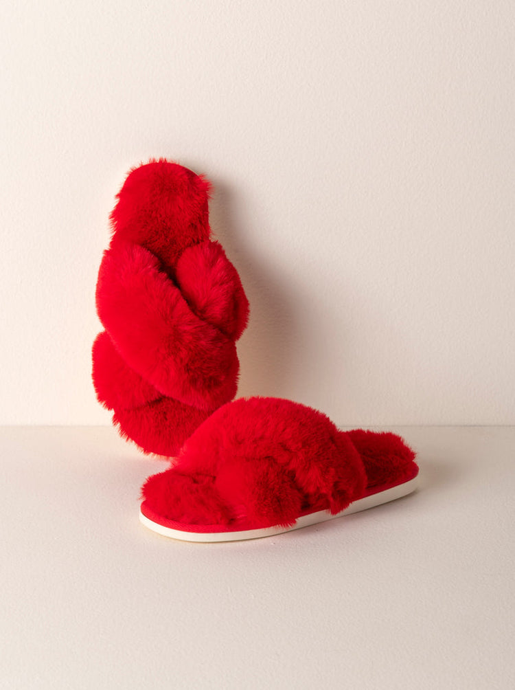 Red fuzzy criss-cross strap slippers with white soles.