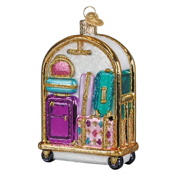 Decorative hotel luggage cart ornament with pastel suitcases on golden wheels.
