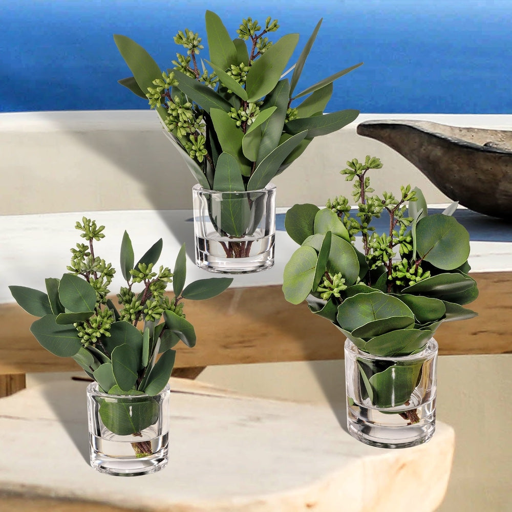 9.5-inch tall natural eucalyptus stem in a clear glass illusion vase with lifelike green leaves.