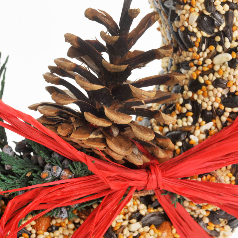 Wildfeast Wreath: a round dried floral arrangement with greenery accented by a natural raffia bow.