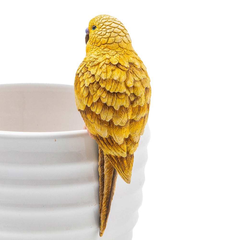 Chartreuse parakeet pot climber figurine made of resin, perched on the edge of a white ceramic pot.