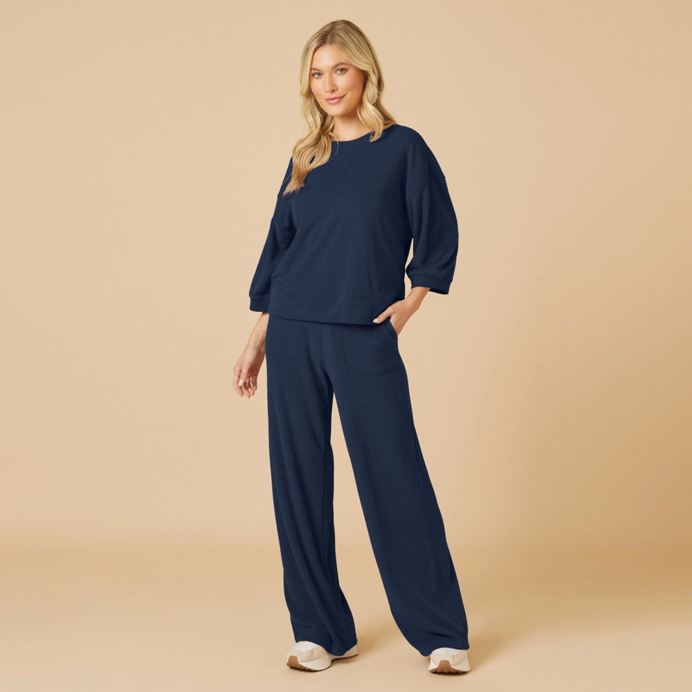 Woman wearing a navy blue Daphne Terry cropped sleeve crew neck top and matching wide leg pants.