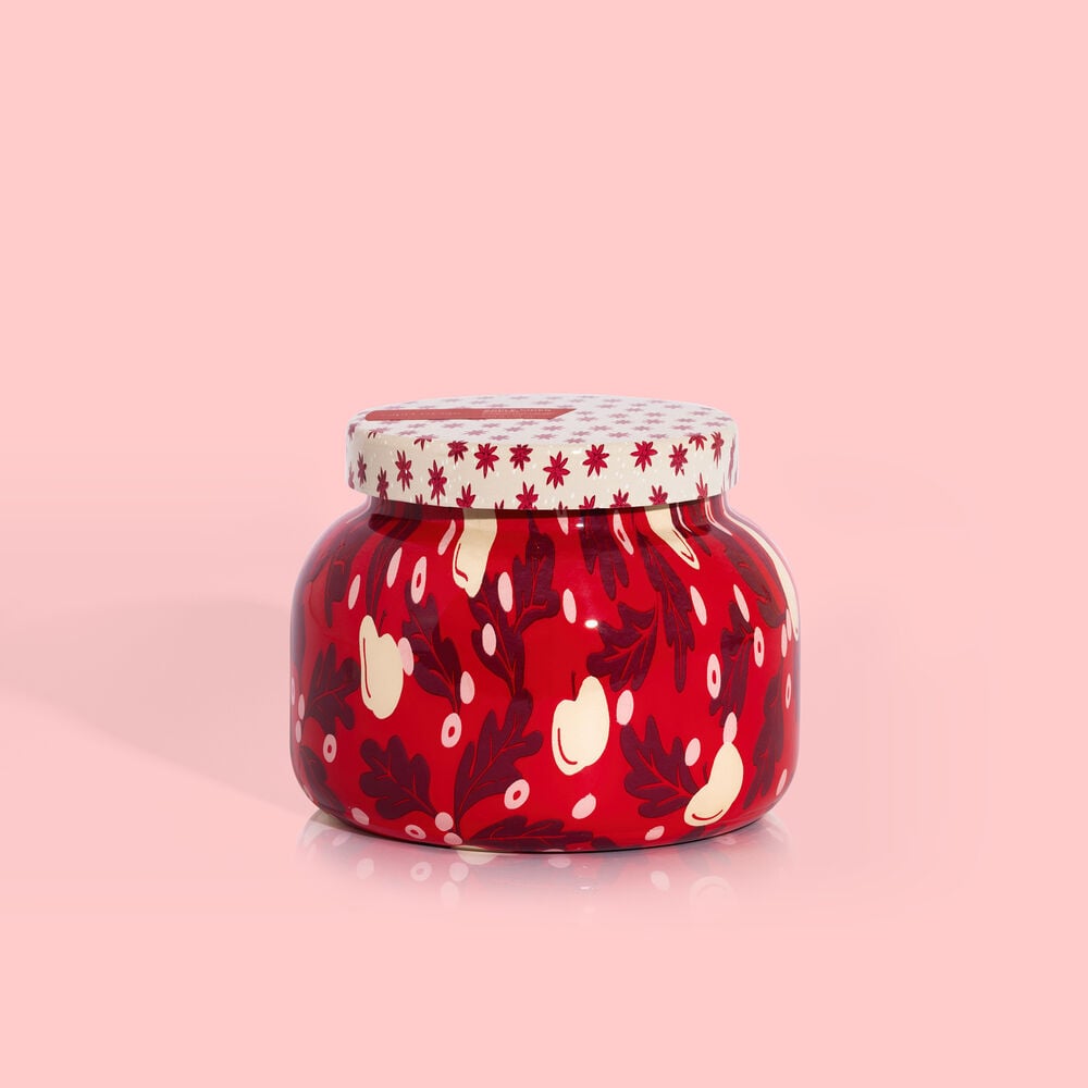White ceramic candle jar with apple cider holiday pattern featuring red apples and green leaves.