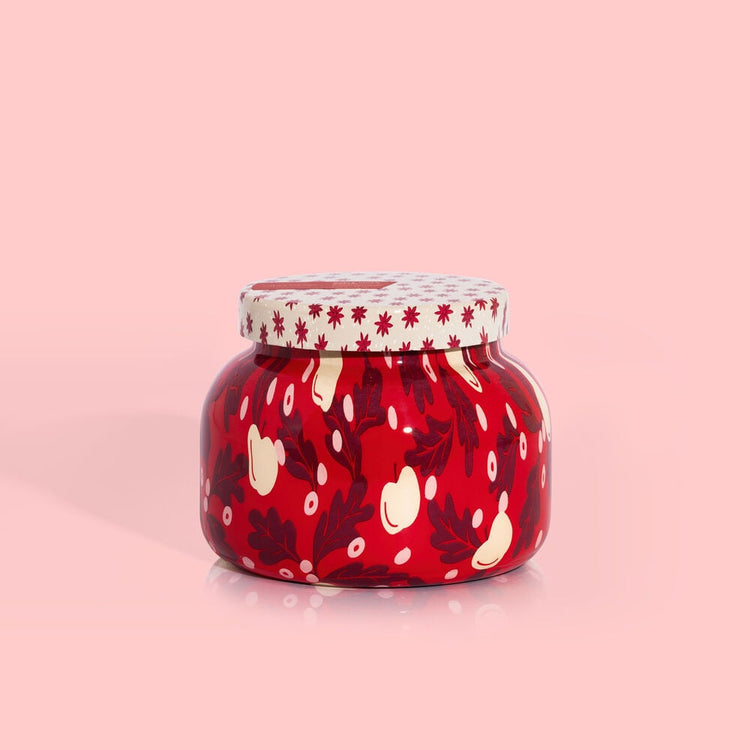 White ceramic candle jar with apple cider holiday pattern featuring red apples and green leaves.
