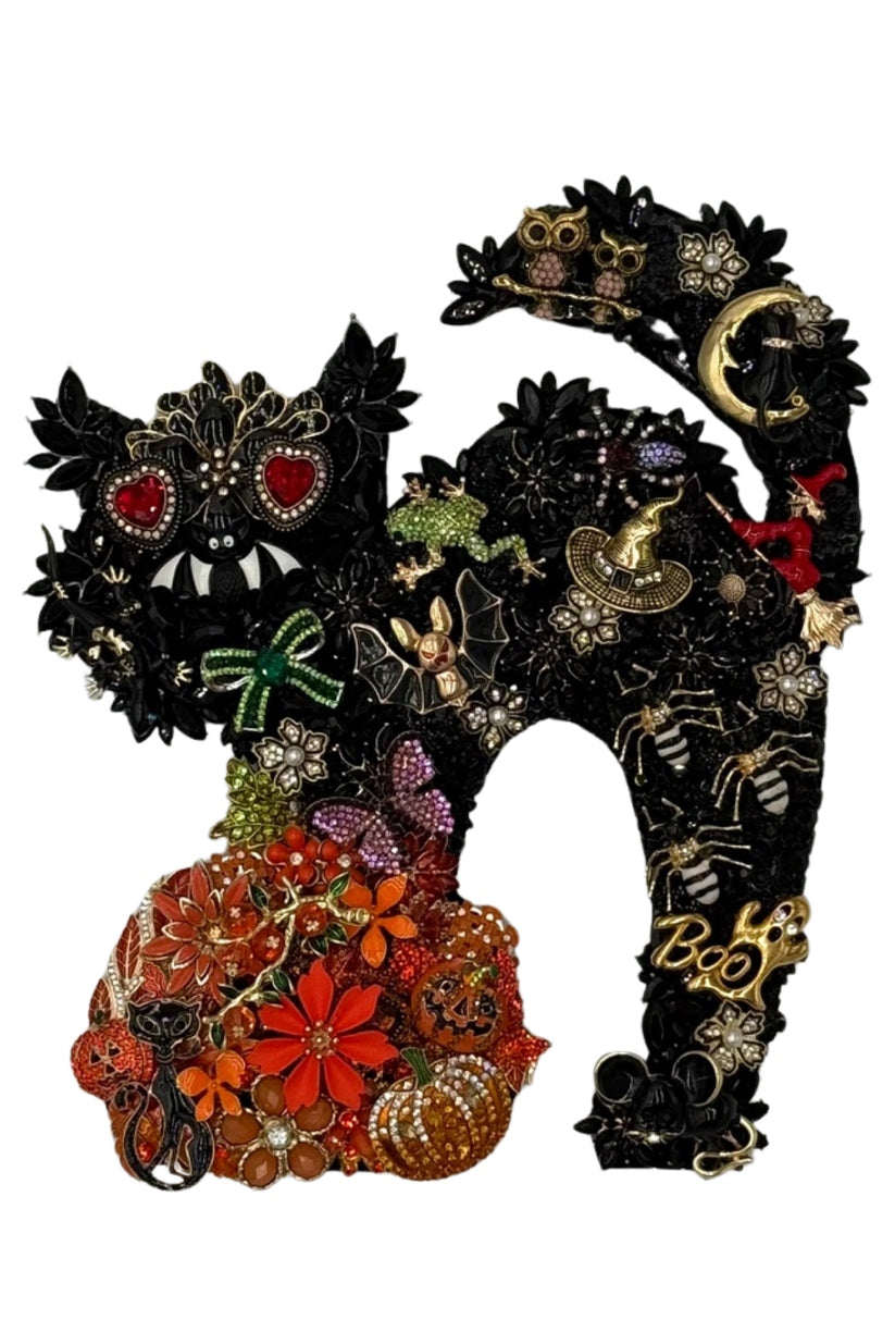 Jeweled black cat silhouette art with Halloween charms, pumpkins, and a witch on a white background.
