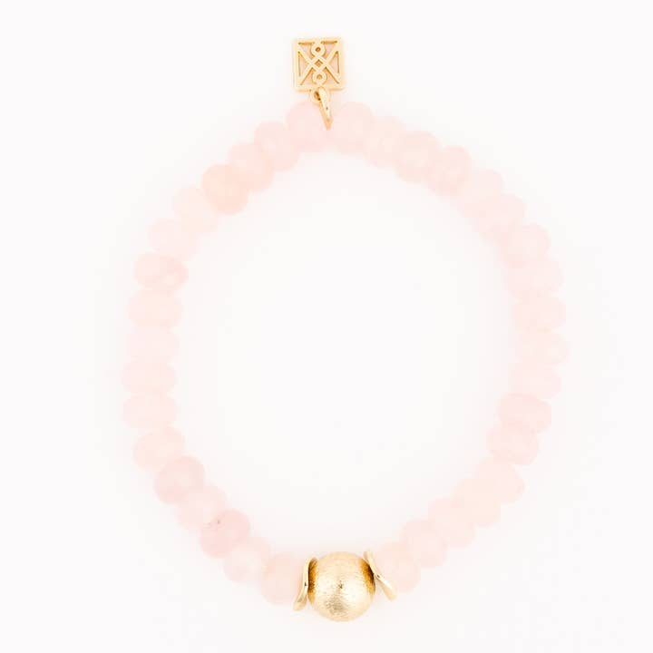 Paloma Blush Bracelet featuring light pink beads, a gold textured bead, and a gold logo charm.