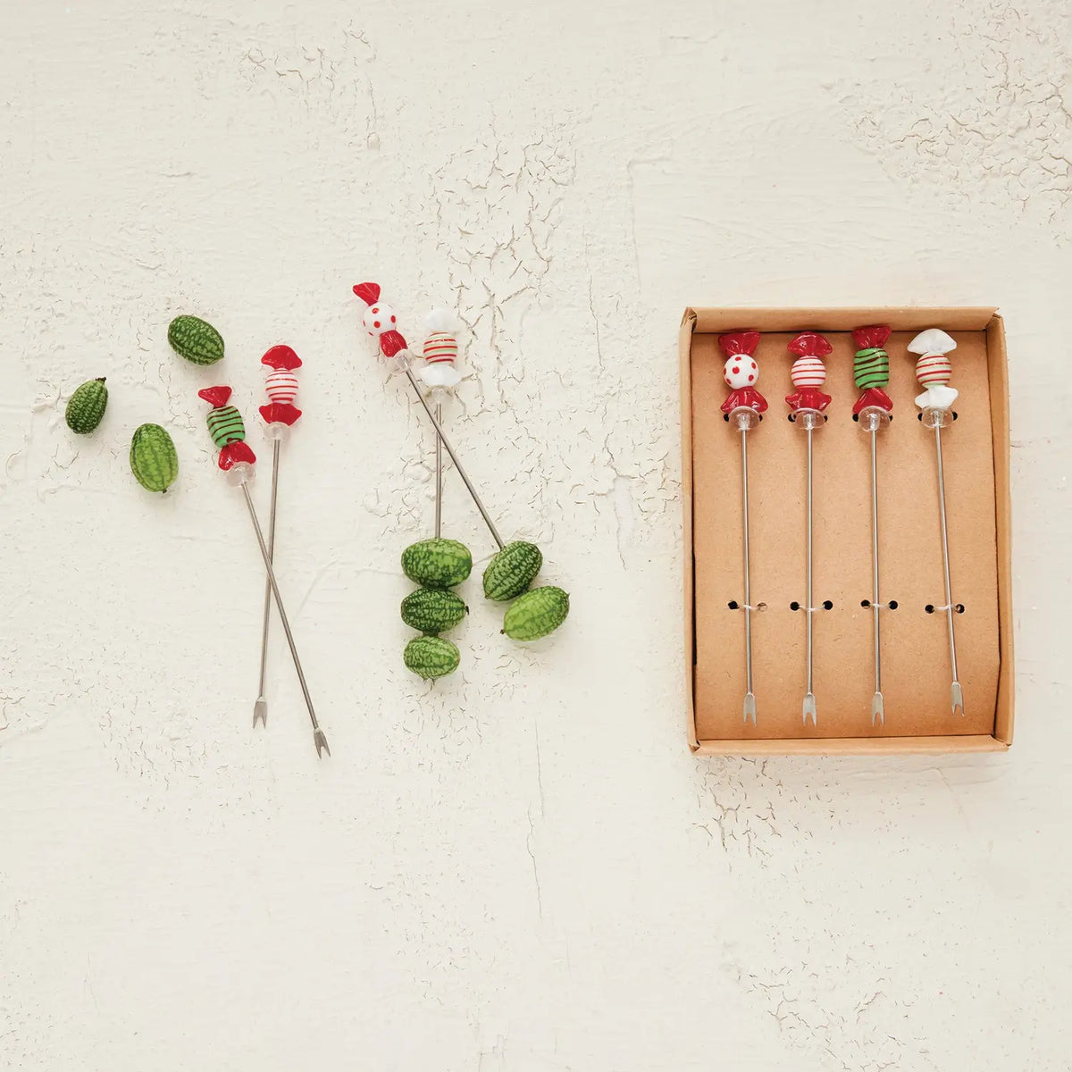 Set of stainless steel appetizer picks topped with colorful blown glass candy accents.