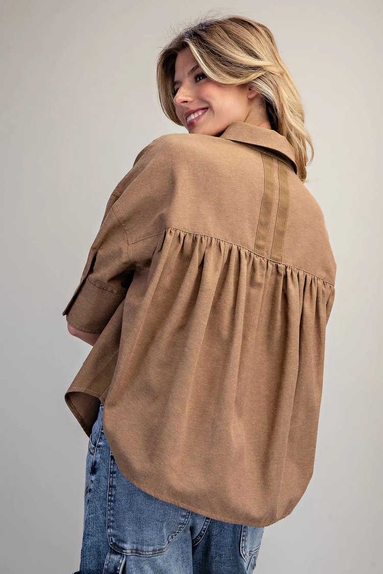 Back view of a woman wearing the brown Lou Button Down Short Sleeve Shirt with gathered back detail.