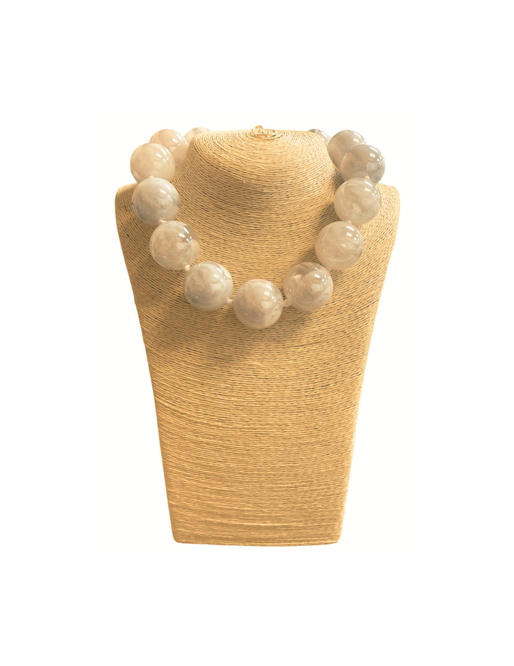 Short necklace featuring large, translucent white glass ball beads on a tan display bust.