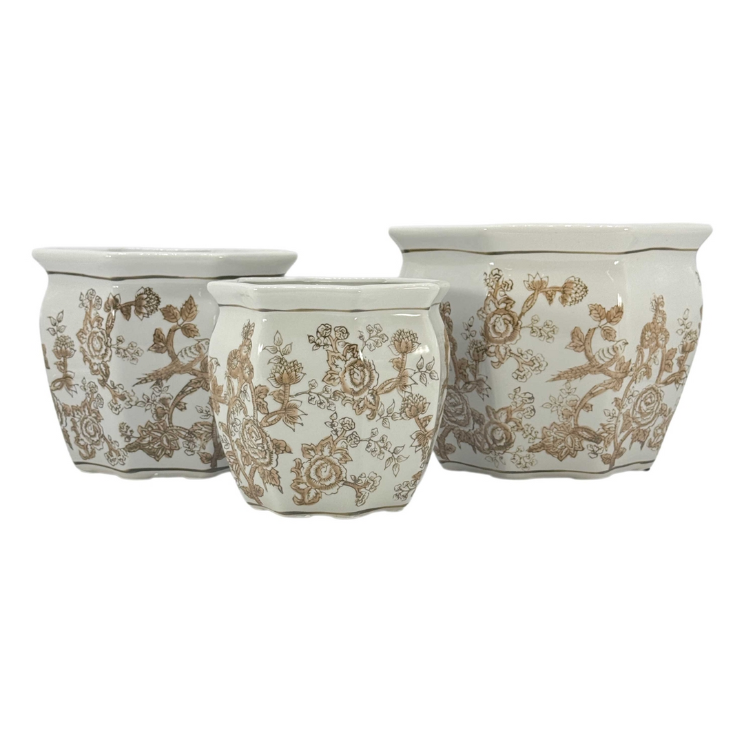 Set of three white ceramic chinoiserie planters with brown floral and bird patterns.