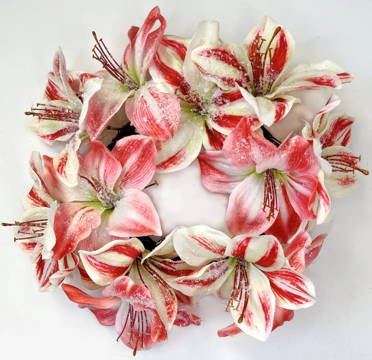 Round ice-textured wreath in amaryllis pink with green foliage accents.