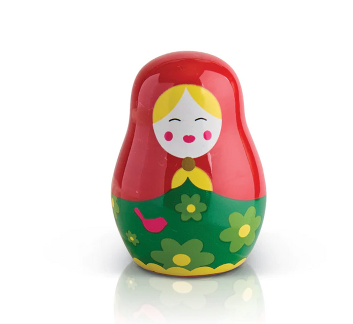 Small red and green nesting doll with a floral pattern and a smiling face.