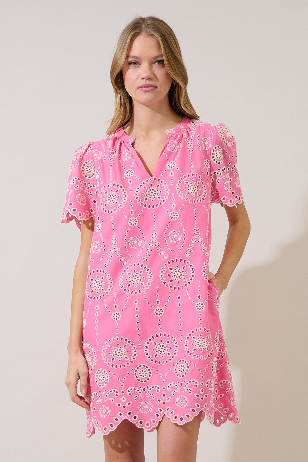 Laurin mini dress in white cotton with embroidered pockets and split neckline.