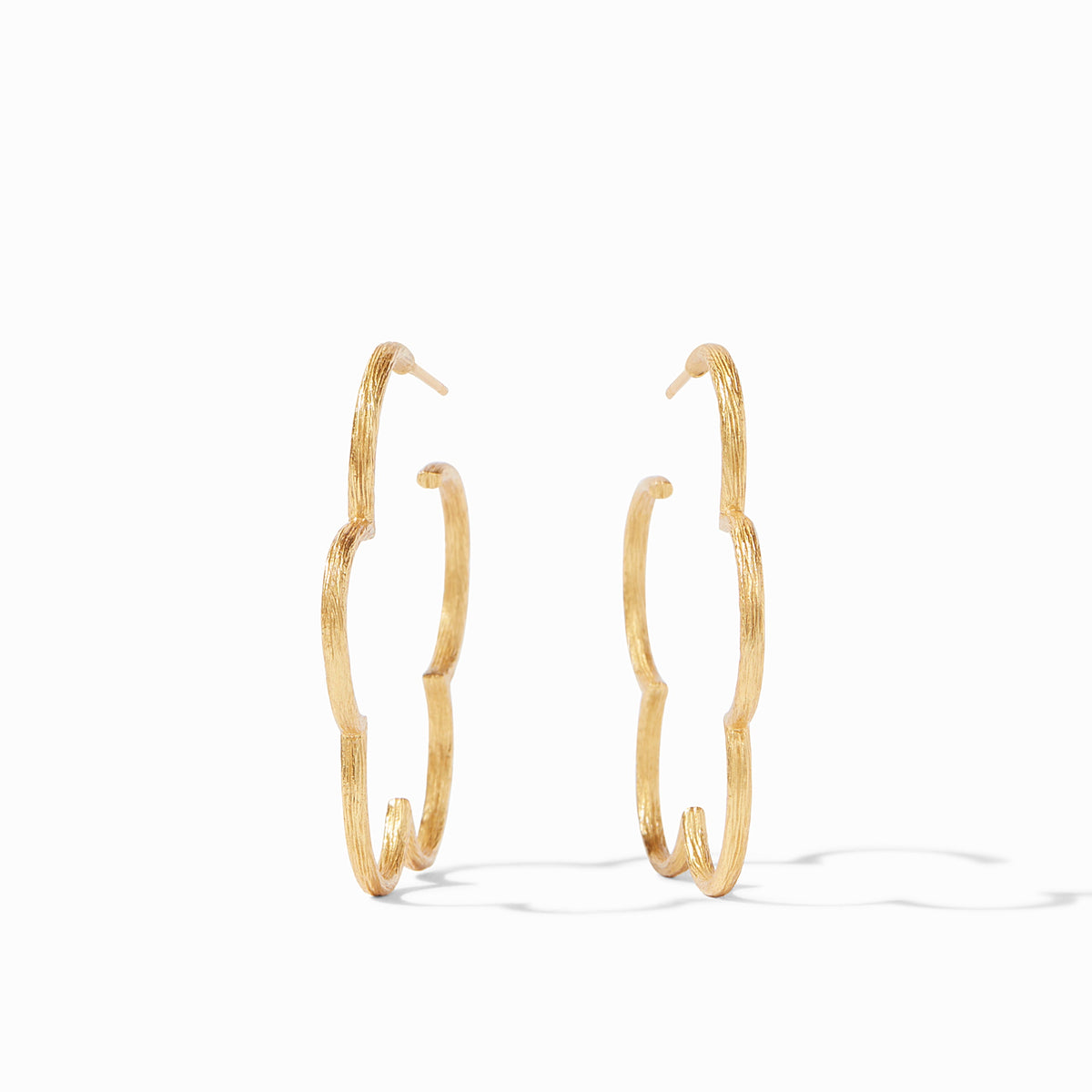 Slender gold hoop earring with a floral gardenia silhouette etched in textured detail.