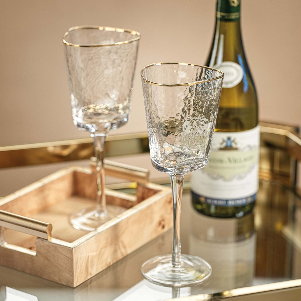 Triangular clear wine glass with gold rim and organic textured finish
