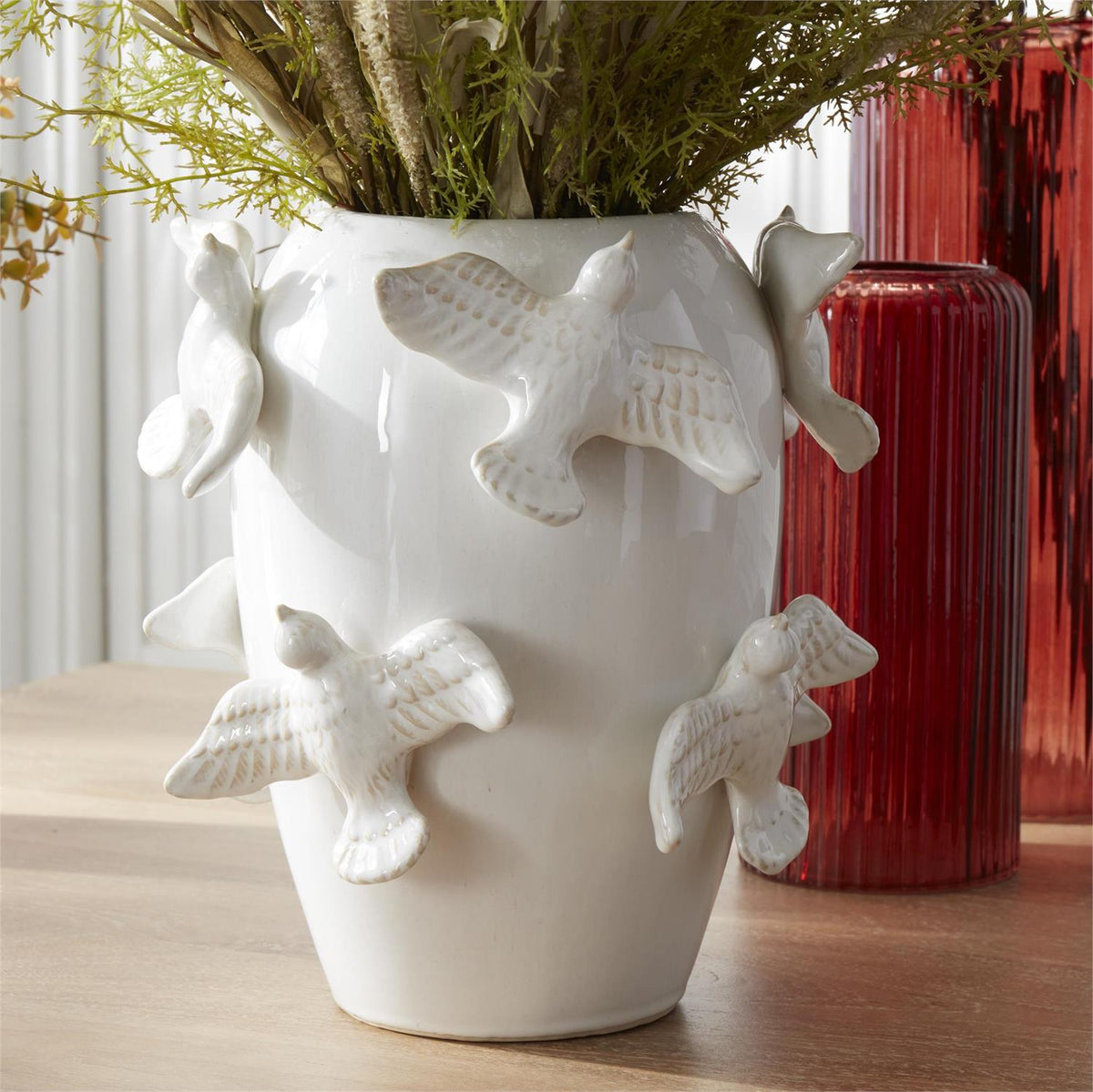 White ceramic vase with an eight-inch-tall three-dimensional bird perched on the rim.