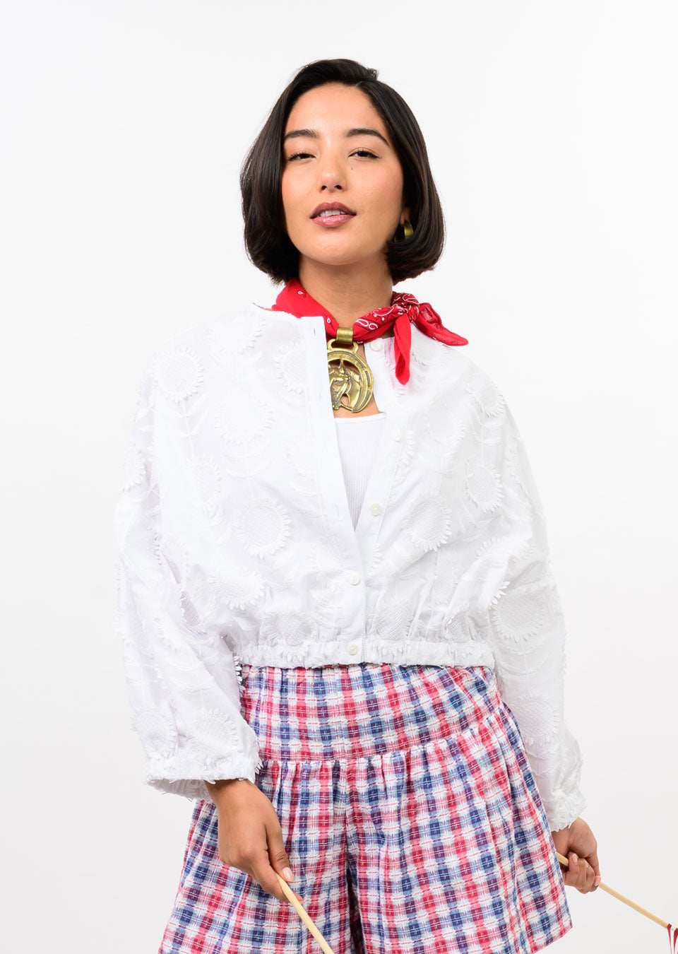 Woman wearing the Sheryl Sundance Jacket, a white cropped fil-coupé jacket with an elasticated hem.