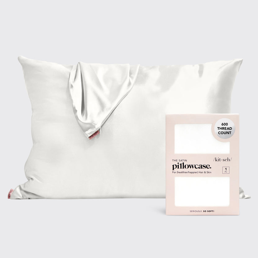 Satin pillowcase in soft neutral tone with smooth texture designed to reduce frizz and prevent facial creases.