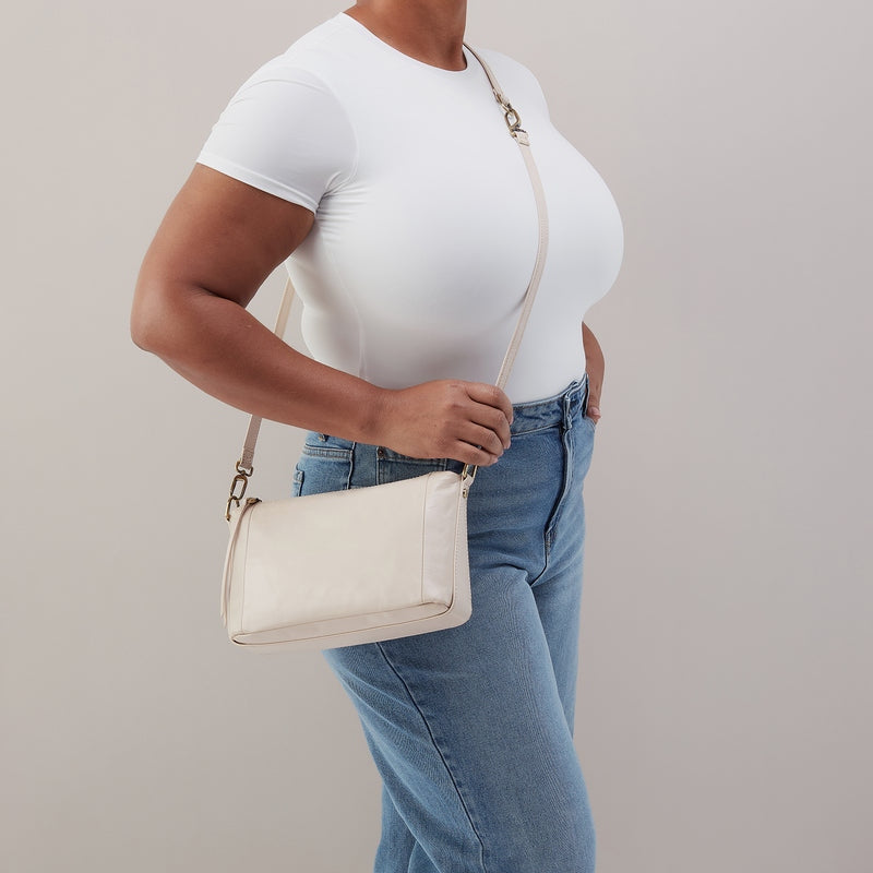 Pale Flax leather Darcy crossbody bag with antique brass hardware and removable strap.