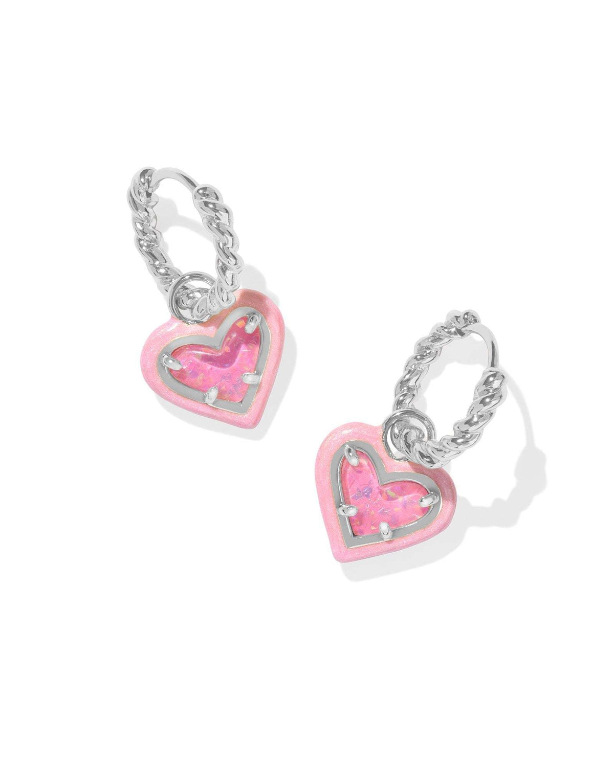 Silver rhodium-plated huggie earrings featuring a textured hoop with an enamel frame surrounding a pink heart charm.