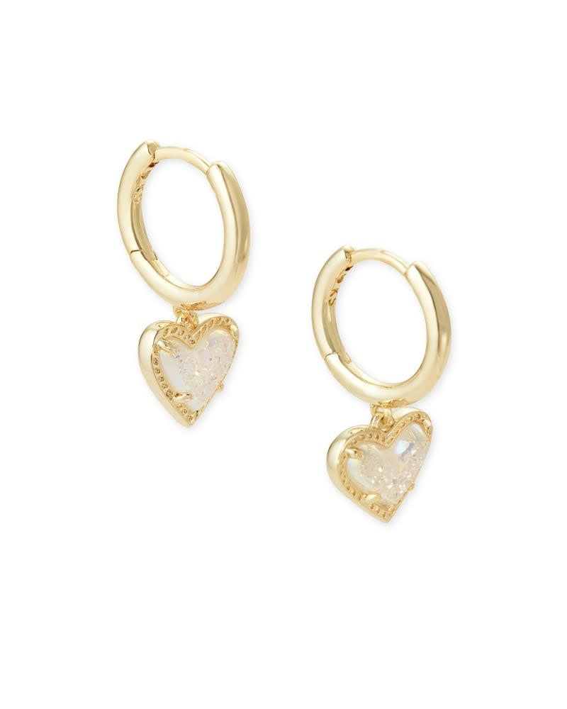 Gold huggie earrings featuring a heart charm with iridescent drusy pattern and asymmetrical silhouette.