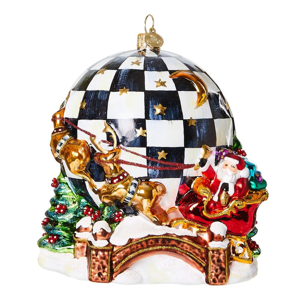 Mouth-blown glass ornament showing Santa in a sleigh circling a Courtly Check world map with brass logo charm.