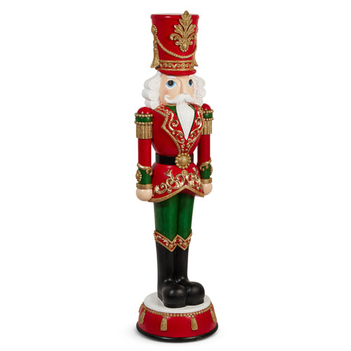 Red and green resin nutcracker figurine with gold accents on a decorative base.