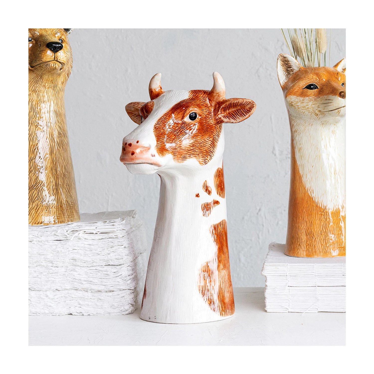 Round stoneware cow vase with hand-painted natural patterns.
