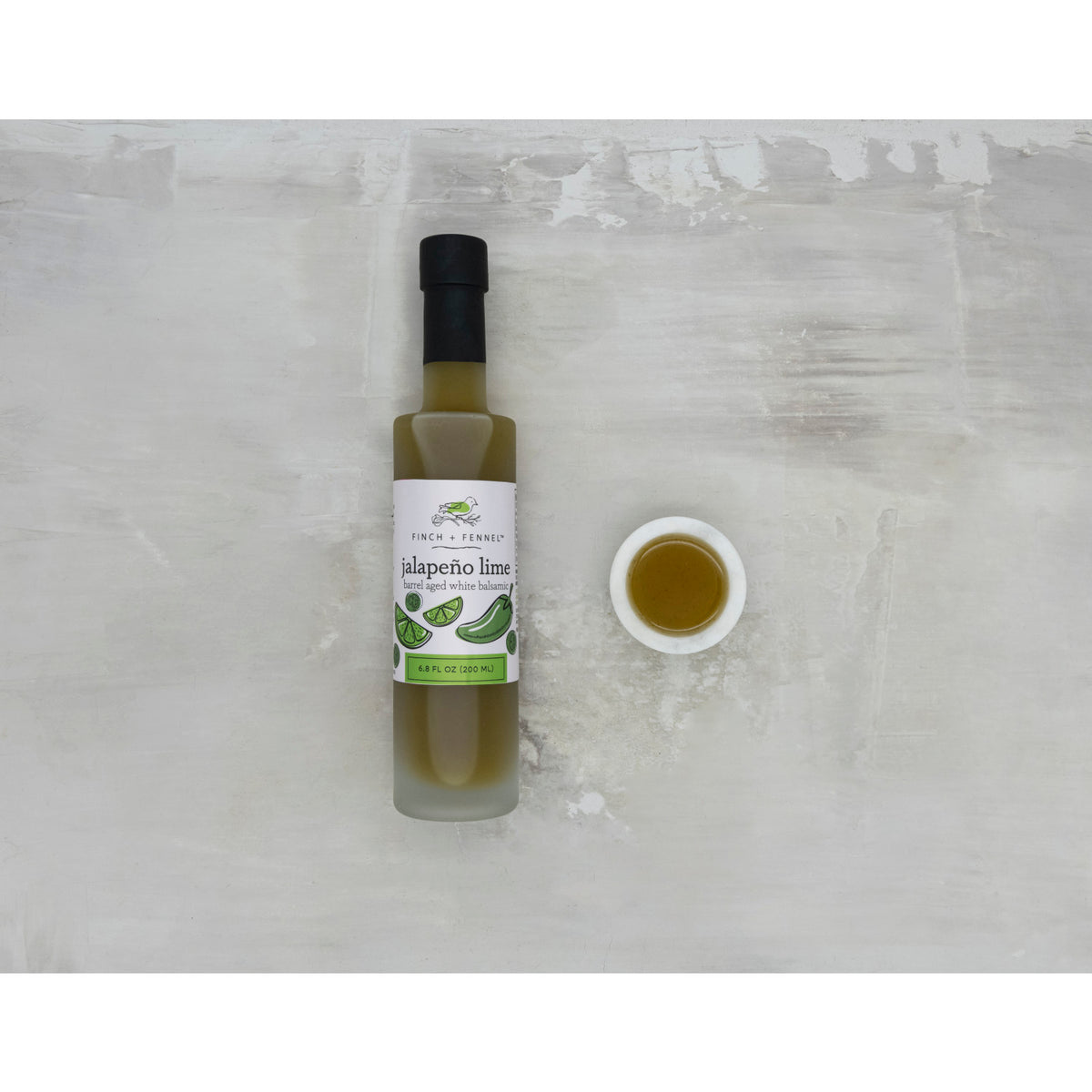 6.8 oz bottle of Jalapeño Lime Barrel Aged White Balsamic vinegar with a white label.