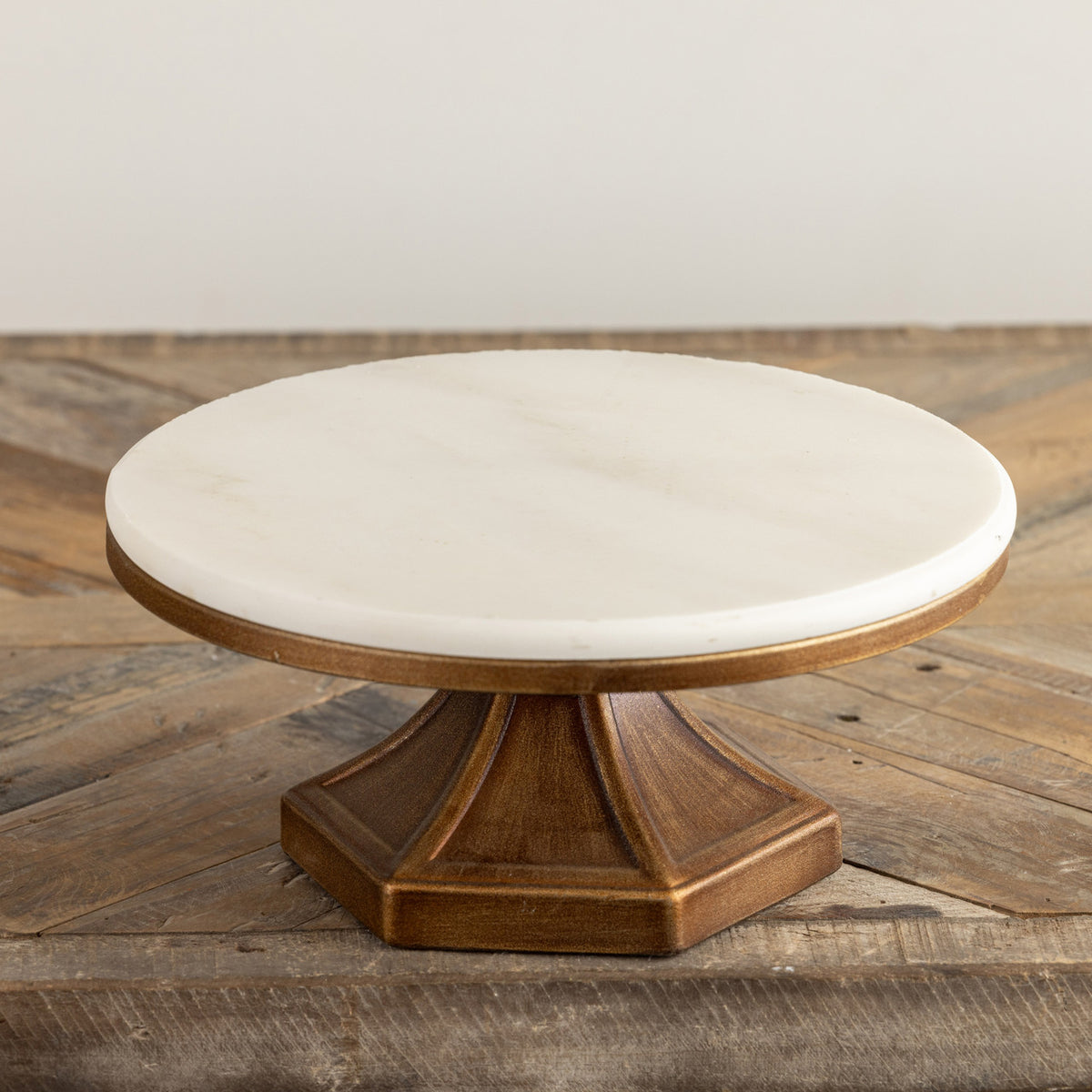 Square metal riser with a white marble top measuring 10 inches wide.
