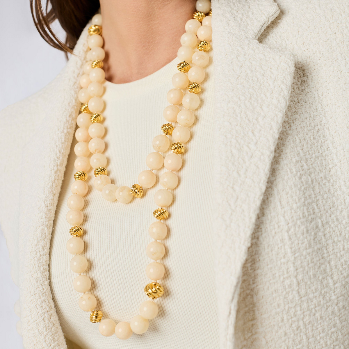 Woman wearing the Ravello 5-in-1 Necklace with cream resin beads and 24K gold plated accents.