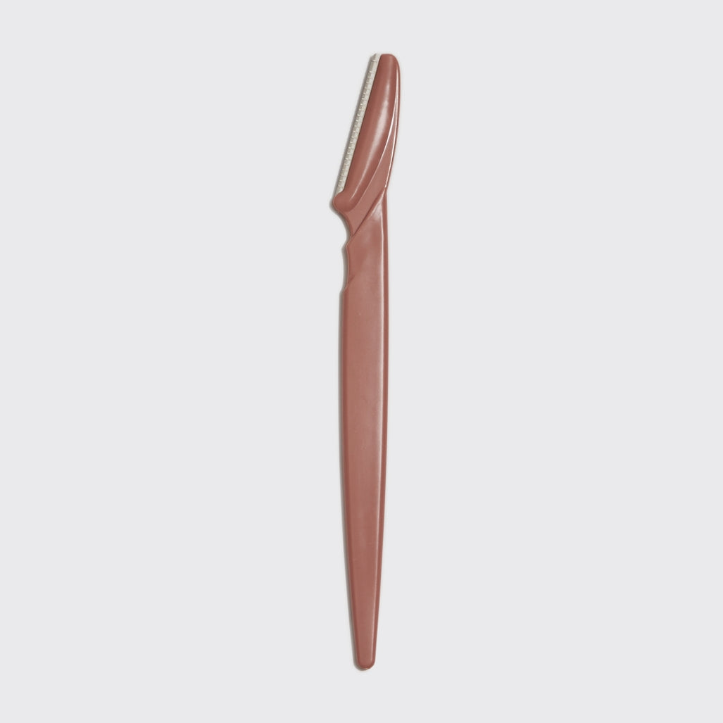 Blush-colored eco-friendly dermaplaner tool with a smooth handle.