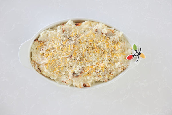 Oval Baker Pinstripes filled with cheesy mashed potatoes on a white countertop.