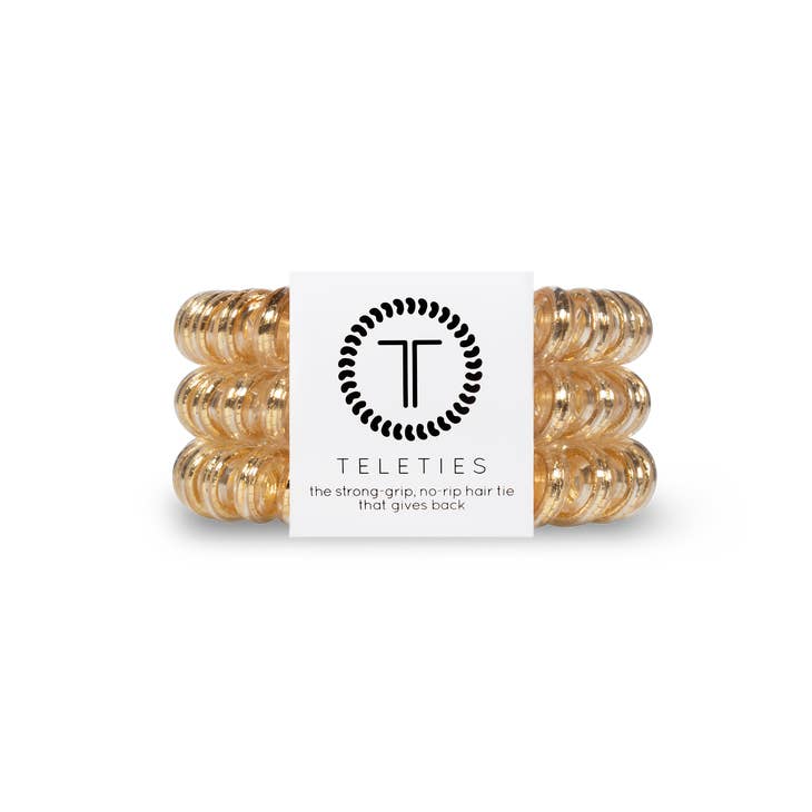 Three large gold spiral hair ties by Teleties in a white branded package.