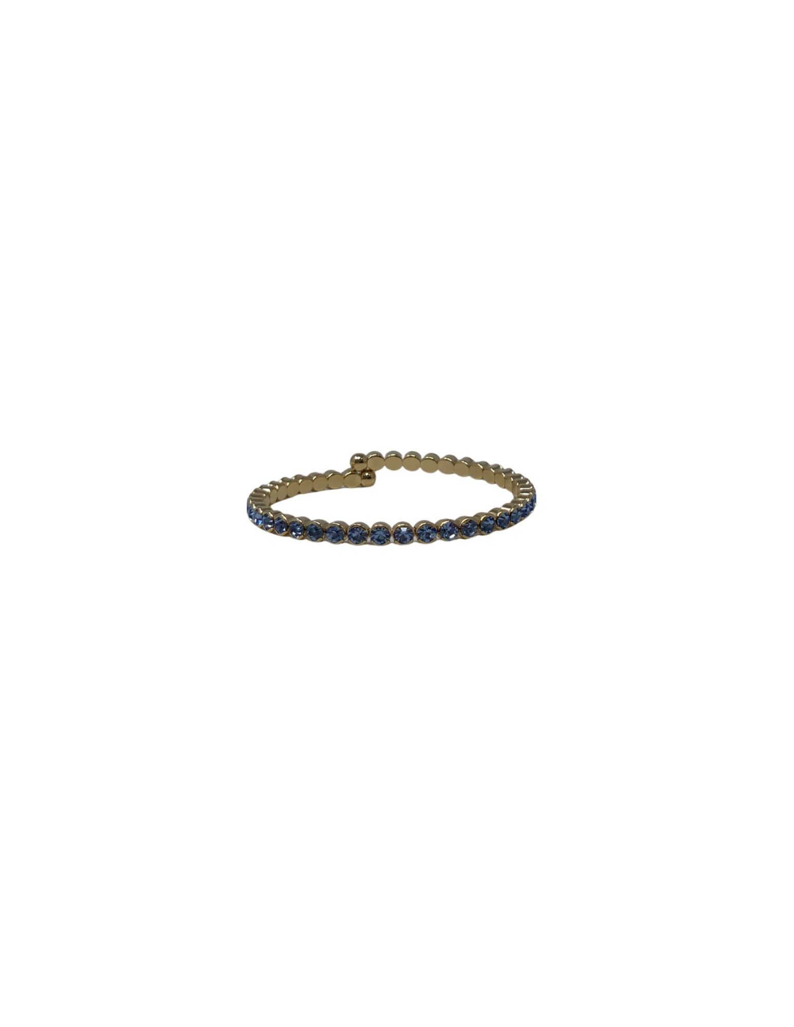 Gold cuff bracelet featuring a row of small, round blue crystals.