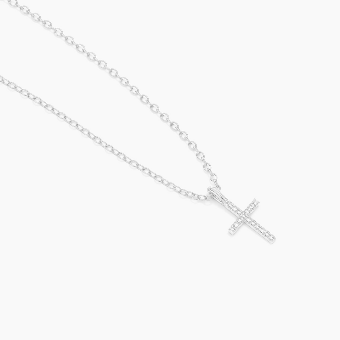 Silver chain necklace featuring a small cross pendant set with sparkling clear stones.