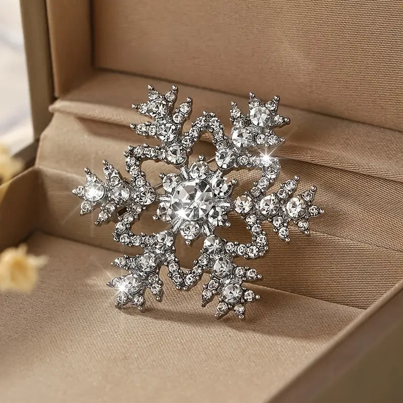 Silver-tone rhinestone brooch shaped like a hollow snowflake with European-American fashion style.