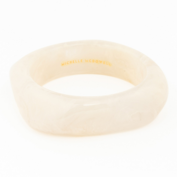 Cream-colored marbled resin Tillie Bangle with a thick, rounded silhouette.