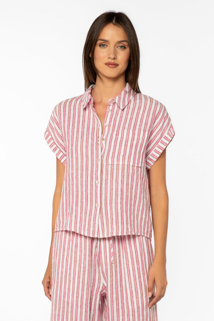 Woman wearing the Kirsty pink and white striped short sleeve collared button-down top.