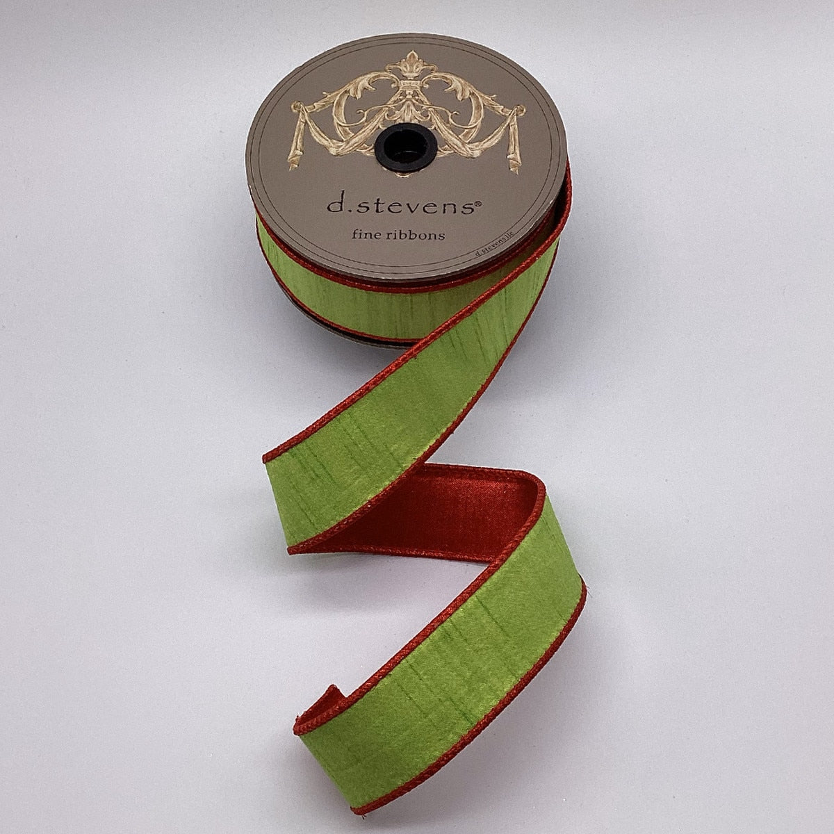 A roll of metallic red dupion fabric with lime green backing.