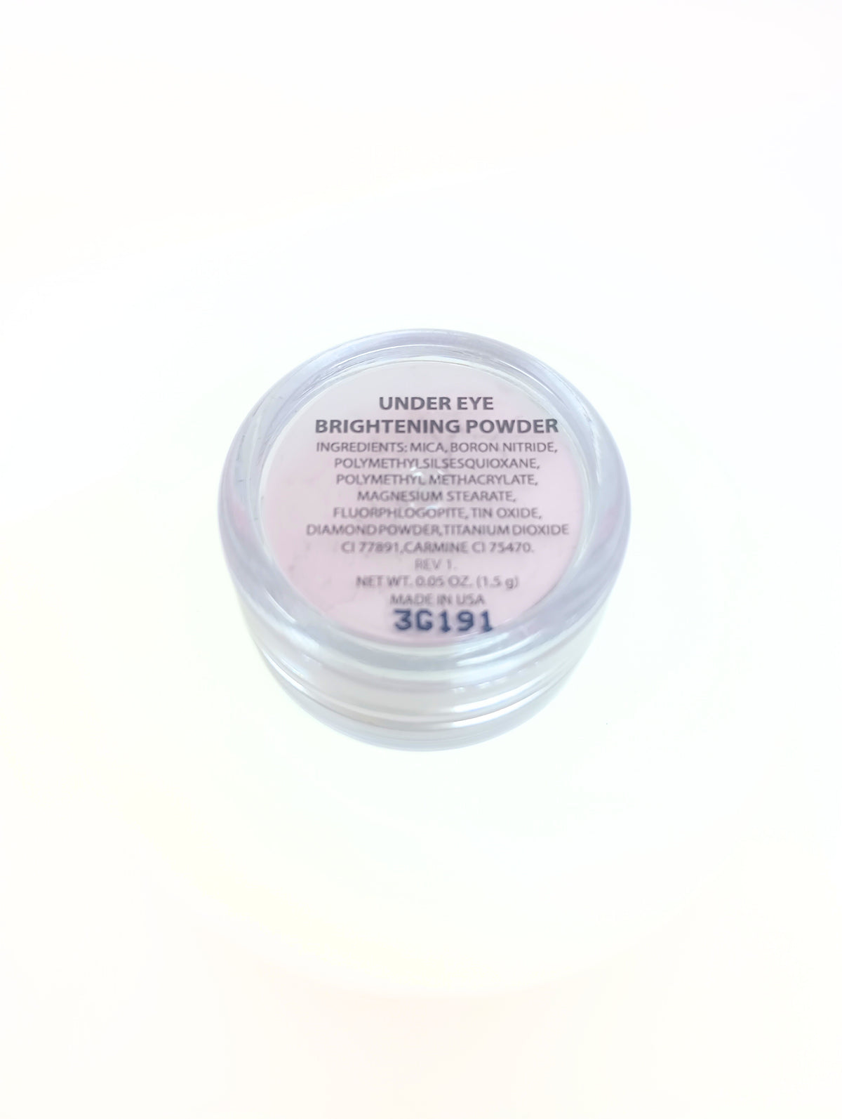 Bottom view of a clear jar of Under Eye Brightening Powder showing ingredients and net weight.